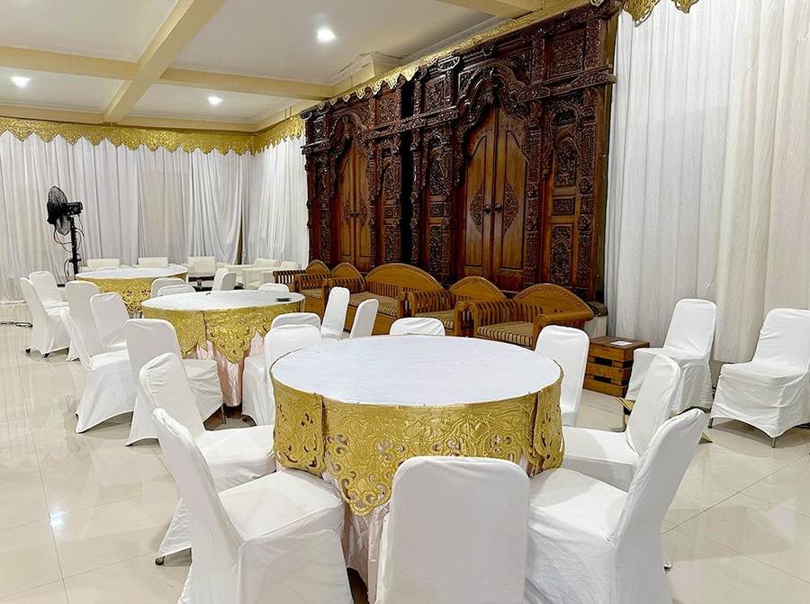Meja bundar tamu dengan latar backdrop ukir kayu