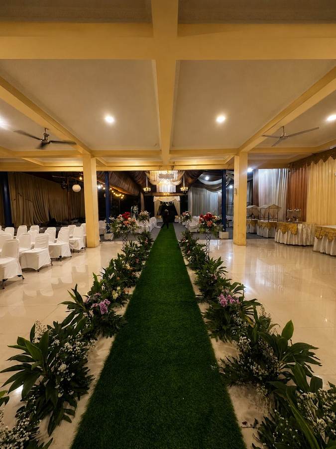 Area tamu lapang dengan kursi putih berjajar di kedua sisi lorong