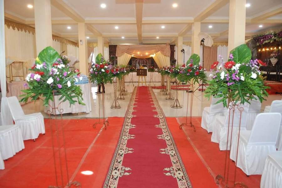 Lorong resepsi dengan standing flower di sepanjang karpet merah