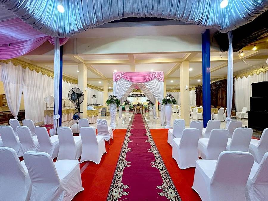 Ruang resepsi berpilar biru dengan karpet merah dan kursi tamu