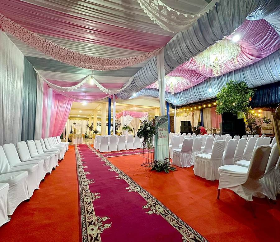 Lorong berkarpet merah dengan drapery merah muda dan lampu gantung