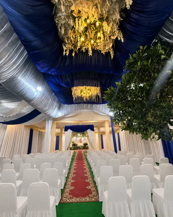 Dekorasi Navy & Silver: plafon tenda navy-silver dengan chandelier bunga di atas lorong karpet merah