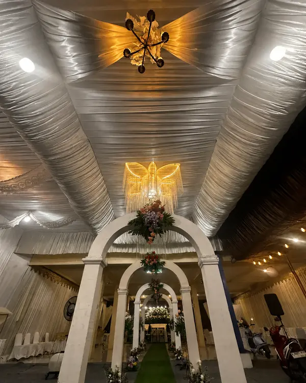 Dekorasi White, Silver & Gold: gate lengkung putih bertingkat di bawah plafon satin silver dan chandelier