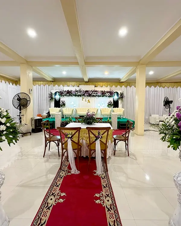 Dekorasi Purple & Cream: lorong karpet merah diapit standing vase bunga ungu menuju pelaminan